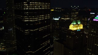 4K aerial stock footage passing by city buildings, Gulf Tower and U.S. Steel Tower, Pittsburgh, night Aerial Stock Footage | AX108_224E