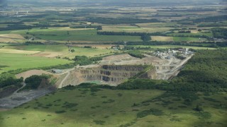 AX109_008E - 5.5K aerial stock footage orbit quarry surrounded by farmland, Denny, Scotland