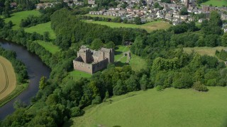 5.5K aerial stock footage of Doune Castle and River Teith among trees, Scotland Aerial Stock Footage | AX109_074E