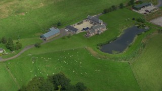 AX109_091 - 5.5K aerial stock footage flyby sheep farm and pond, Stirling, Scotland