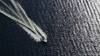 AX110_121 - 5.5K aerial stock footage of tracking fishing boat on calm blue waters, Loch Lomond, Scottish Highlands, Scotland