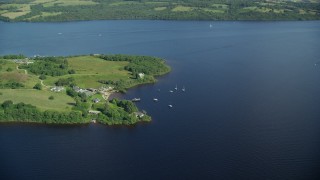 AX110_124 - 5.5K aerial stock footage of orbiting sailboats along a Loch Lomond island, Scottish Highlands, Scotland