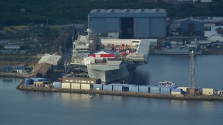 5.5K aerial stock footage of an aircraft carrier at Rosyth Dockyard on Firth of Forth, Scotland Aerial Stock Footage | AX111_056E