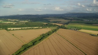 AX111_103E - 5.5K aerial stock footage fly over rural landscape of farmland and trees, Edinburgh, Scotland