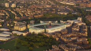 AX112_059E - 5.5K aerial stock footage of an orbit of Easter Road soccer stadium, Edinburgh, Scotland at sunset