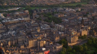 5.5K aerial stock footage reverse view of Lloyds Bank Headquarters, reveal Scott Monument and train station, Edinburgh, Scotland at sunset Aerial Stock Footage | AX112_078E