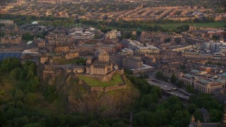 5.5K aerial stock footage of Edinburgh Castle on a hill with a view of cityscape, Scotland at sunset Aerial Stock Footage | AX112_080E