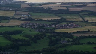 5.5K aerial stock footage of farmland and rural homes in a village near Falkirk, Scotland at twilight Aerial Stock Footage | AX112_139