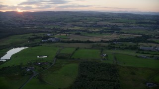 5.5K aerial stock footage of passing by farms and farm fields at sunset in Bonnybridge, Scotland Aerial Stock Footage | AX112_156