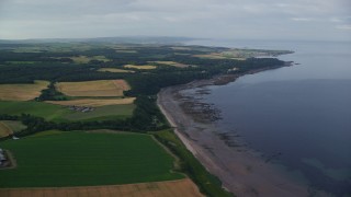 5.5K aerial stock footage fly over farm fields and beach along Firth of Clyde, Maybole, Scotland Aerial Stock Footage | AX113_053