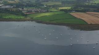 AX113_150 - 5.5K aerial stock footage of sailboats in the harbor and farmland along the shore, Strangford Lough, Northern Ireland