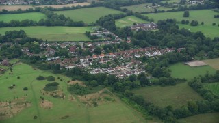 AX114_001E - 5.5K aerial stock footage of homes in a village, Banstead, England