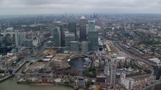 AX114_149E - 5.5K aerial stock footage fly over Canary Wharf skyscrapers toward River Thames, London, England