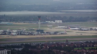 5.5K aerial stock footage of the control tower and airliner at London Heathrow Airport, England Aerial Stock Footage | AX114_286E