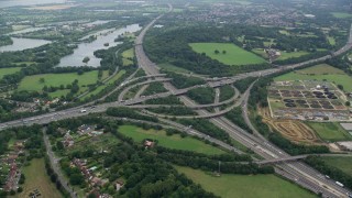 AX114_350E - 5.5K aerial stock footage of orbiting M3 and M25 Interchange, Egham, England