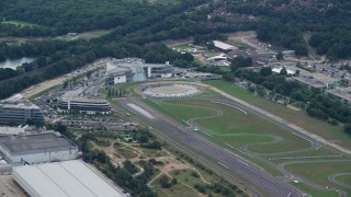 AX114_358 - 5.5K aerial stock footage of orbiting office buildings and a race track, Weybridge, England