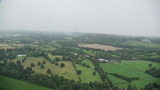 5.5K aerial stock footage of flying through low clouds by farms and trees, Redhill, England Aerial Stock Footage | AX115_003E