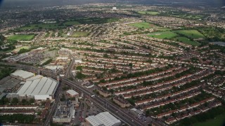 AX115_040E - 5.5K aerial stock footage of flying homes and shopping center by highway, New Malden, England