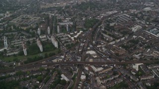 5.5K aerial stock footage fly over residential area with train tracks in the rain, London, England Aerial Stock Footage | AX115_056