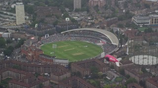 AX115_058E - 5.5K aerial stock footage of The Oval cricket stadium in the rain, London, England