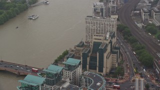 5.5K aerial stock footage of orbiting the MI6 Building revealing skyscraper in the rain, London, England Aerial Stock Footage | AX115_069E