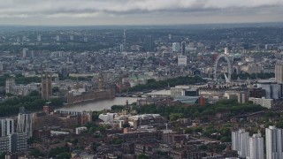 5.5K aerial stock footage of city sprawl behind Parliament and London Eye, England Aerial Stock Footage | AX115_147