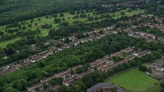 5.5K aerial stock footage of passing residential neighborhoods and trees, Coulsdon, England Aerial Stock Footage | AX115_301E