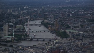 AX116_094E - 5.5K aerial stock footage of London Eye, bridges over River Thames, Big Ben and British Parliament, London, England, twilight