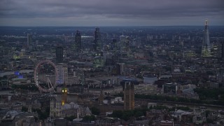 5.5K aerial stock footage passing London Eye, Big Ben and British Parliament by River Thames, London, England, night Aerial Stock Footage | AX116_118