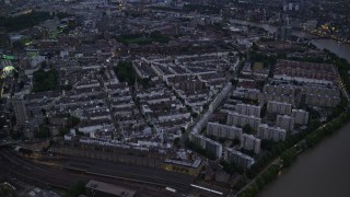 5.5K aerial stock footage tilt from Chelsea Bridge and River Thames to reveal apartments and cityscape, London, England, night Aerial Stock Footage | AX116_137E