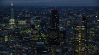 5.5K aerial stock footage of The Gherkin skyscraper, seen from near Heron Tower, London, England, night Aerial Stock Footage | AX116_166E