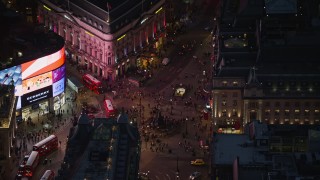 AX116_182E - 5.5K aerial stock footage flying by crowds and double decker buses at Piccadilly Circus, London, England, night