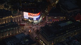 AX116_185 - 5.5K aerial stock footage of orbiting crowds and buses at Piccadilly Circus, London, England, night