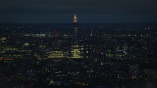 5.5K aerial stock footage of The Shard towering over city buildings, London, England, night Aerial Stock Footage | AX116_198E