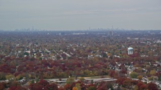 5.5K aerial stock footage of a suburban neighborhood and NYC skyline in Autumn, Farmingdale, New York Aerial Stock Footage | AX117_003