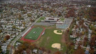 AX117_033E - 5.5K aerial stock footage of a suburban high school in Autumn, Merrick, New York