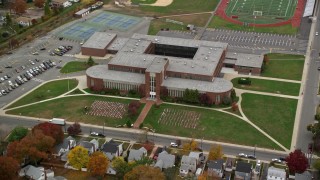 5.5K aerial stock footage of orbiting flags at high school in Autumn, Merrick, New York Aerial Stock Footage | AX117_035E