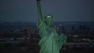 AX118_046E - 5.5K aerial stock footage orbit Statue of Liberty at sunrise, with New York City in the background