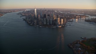 AX118_084E - 5.5K aerial stock footage of a slow approach to skyscrapers in Lower Manhattan at sunrise, New York City