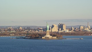 5.5K aerial stock footage of the Statue of Liberty and high-rises at sunrise in New York Aerial Stock Footage | AX118_137E