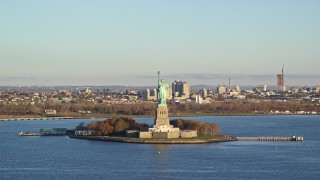 5.5K aerial stock footage of an approach to the Statue of Liberty at sunrise in New York Aerial Stock Footage | AX118_142E