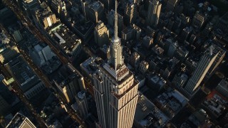 AX118_181E - 5.5K aerial stock footage approach and tilt to bird's eye of the Empire State Building at sunrise in New York City