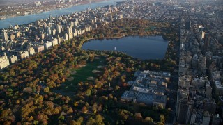 AX118_192 - 5.5K aerial stock footage of Central Park and The Met with Autumn leaves at sunrise in New York City