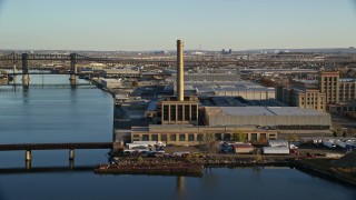 AX118_227 - 5.5K aerial stock footage of riverfront factory at sunrise in Kearny, New Jersey