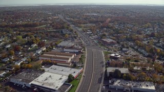 5.5K aerial stock footage of warehouses on a wide street in Autumn, Farmingdale, New York Aerial Stock Footage | AX120_001E