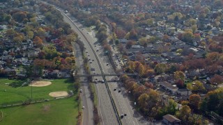 5.5K aerial stock footage orbit light traffic on a freeway in Autumn, Seaford, New York Aerial Stock Footage | AX120_010