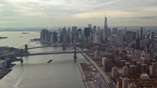 AX120_140E - 5.5K aerial stock footage approach Brooklyn and Manhattan Bridges and Lower Manhattan from East River, New York City