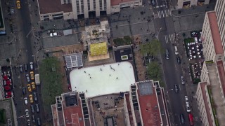 AX120_189E - 5.5K aerial stock footage of circling above the ice skating rink at Rockefeller Center in Midtown, New York City