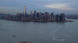 AX121_014 - 5.5K aerial stock footage fly over Ellis Island toward Lower Manhattan skyline at twilight, New York City