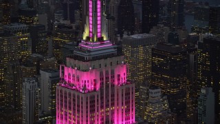 AX121_109 - 5.5K aerial stock footage orbiting around the top of Empire State Building at twilight in Midtown Manhattan, New York City